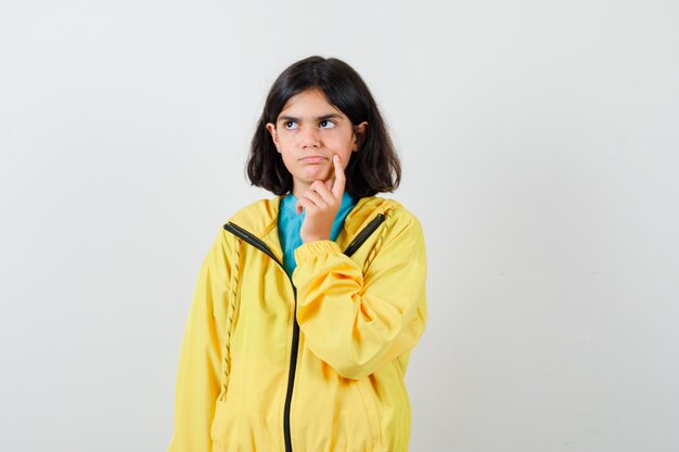 Retrato de uma menina em pé pensando em pose de camisa, jaqueta e olhando pensativamente vista frontal