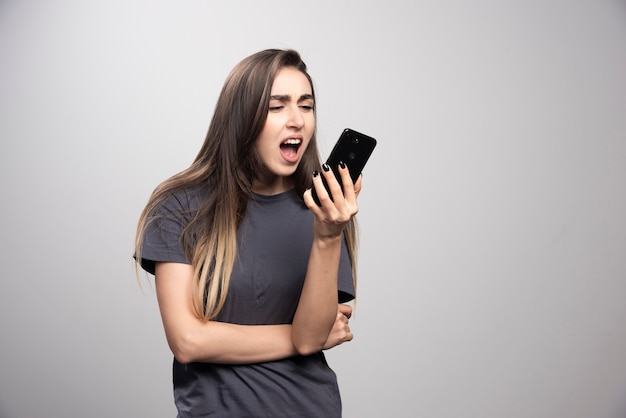 Retrato de uma menina falando no celular e desviar o olhar.