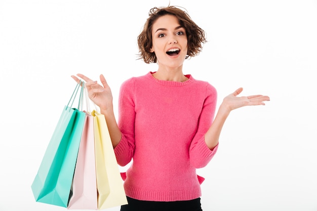 Foto grátis retrato de uma menina feliz animada segurando sacolas de compras