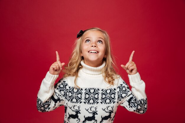 Retrato de uma menina feliz na camisola de Natal