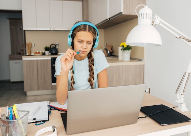 Foto grátis retrato de uma menina prestando atenção nas aulas online