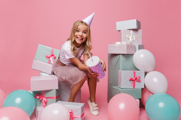 Retrato de uma menina sorridente em um chapéu de aniversário