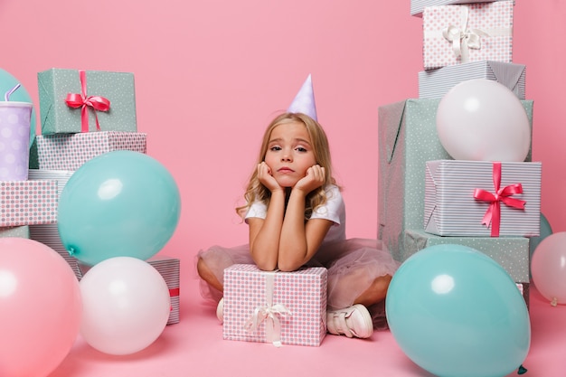 Retrato de uma menina triste em um chapéu de aniversário