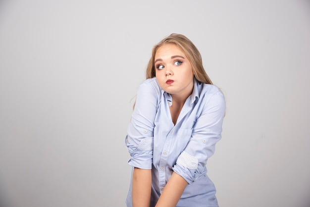 Foto grátis retrato de uma modelo de mulher bonita em pé e soprando as bochechas