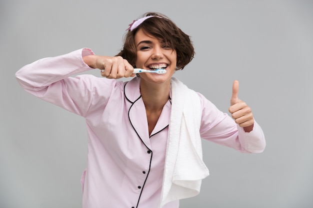 Retrato de uma mulher alegre e feliz de pijama e toalha