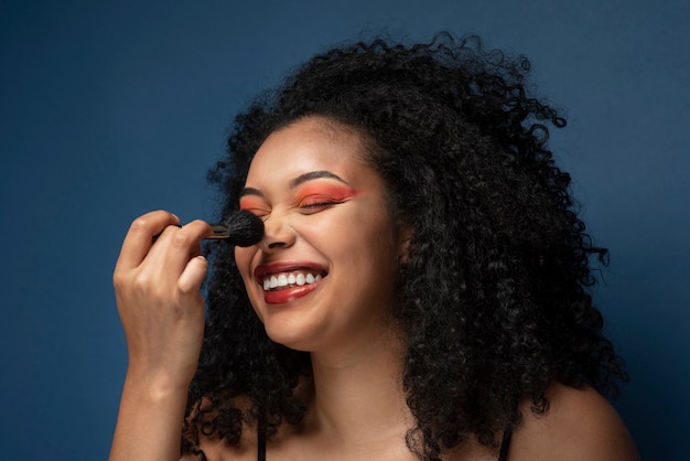 Retrato de uma mulher aplicando maquiagem com um pincel de maquiagem