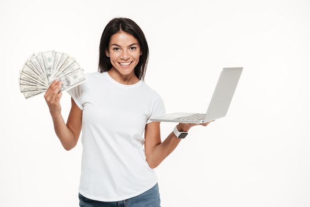 Foto grátis retrato de uma mulher atraente feliz segurando computador portátil