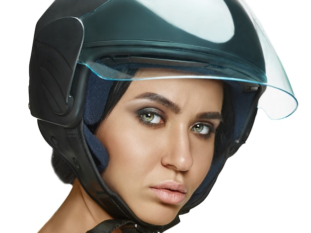 Retrato de uma mulher atraente no capacete de moto em fundo branco. conceito de beleza e proteção para a pele