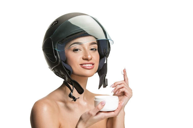 Retrato de uma mulher atraente no capacete de moto em fundo branco do estúdio. Conceito de beleza, proteção para pele e rosto