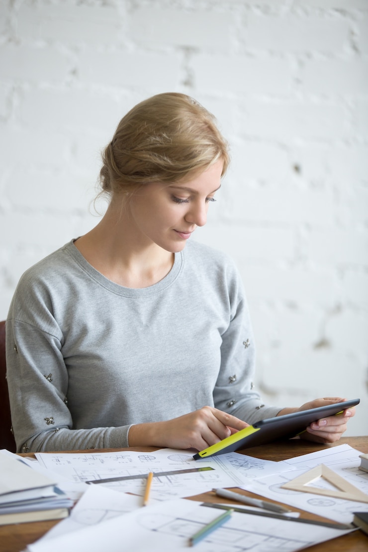 Foto grátis retrato de uma mulher atraente trabalhando com um tablet