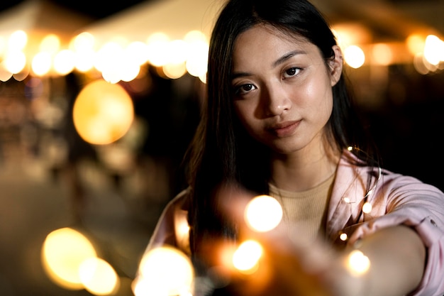 Retrato de uma mulher bonita à noite nas luzes da cidade