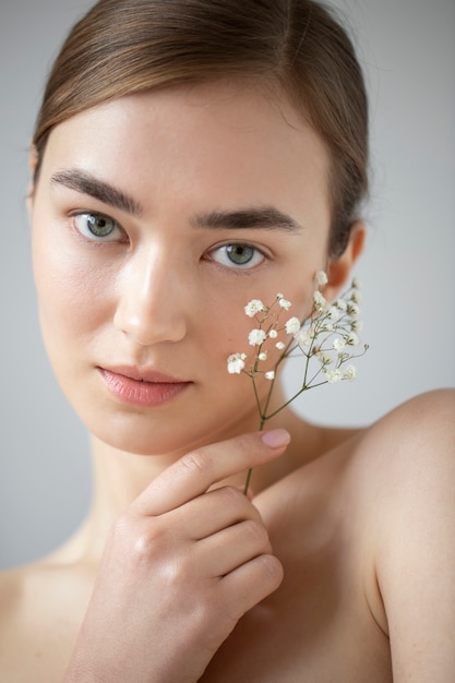 Retrato de uma mulher bonita com pele clara, posando com flores de respiração do bebê