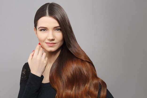 Retrato de uma mulher bonita com penteado moderno em estúdio. Senhora bonita de vestido preto, olhando para a câmera. Conceito de penteado.