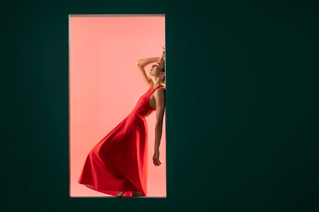 Retrato de uma mulher bonita posando com um vestido vermelho esvoaçante