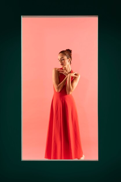 Retrato de uma mulher bonita posando com um vestido vermelho esvoaçante