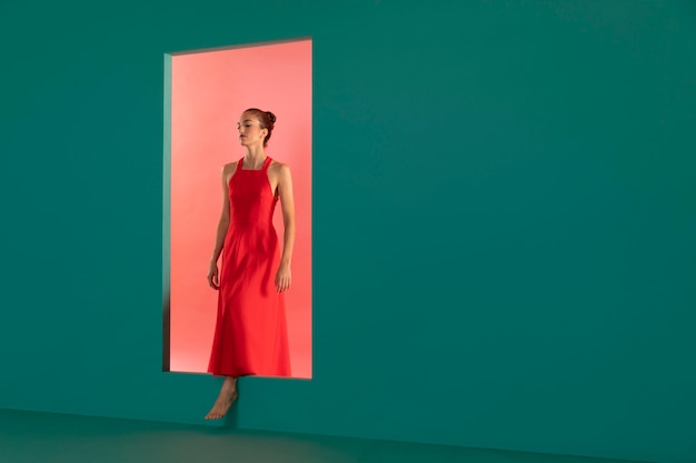 Foto grátis retrato de uma mulher bonita posando com um vestido vermelho fluido com espaço de cópia