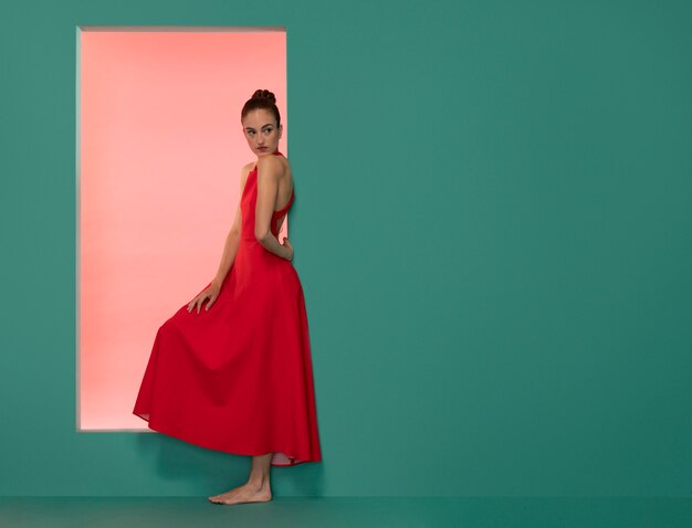 Retrato de uma mulher bonita posando com um vestido vermelho fluido com espaço de cópia