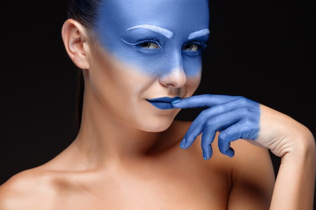 Retrato de uma mulher coberta com maquiagem artística azul