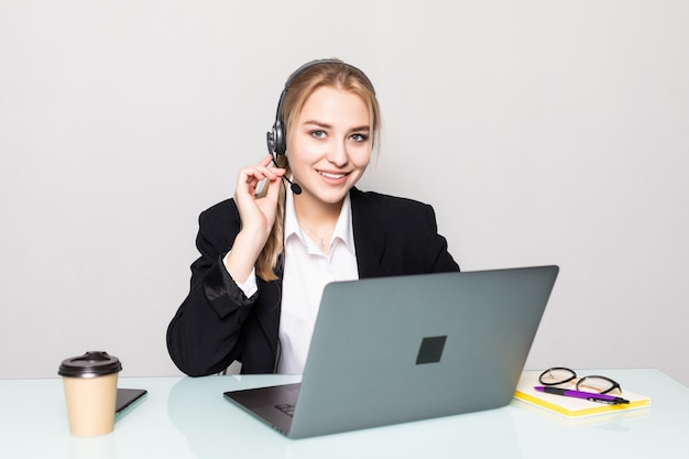 Retrato de uma mulher de negócios sorridente com um fone de ouvido no trabalho em um call center no escritório