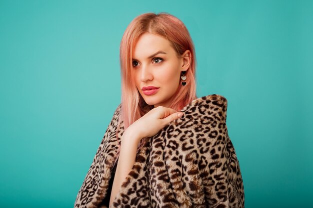 Retrato de uma mulher deslumbrante com cabelo rosa com casaco macio de inverno elegante com estampa de leopardo