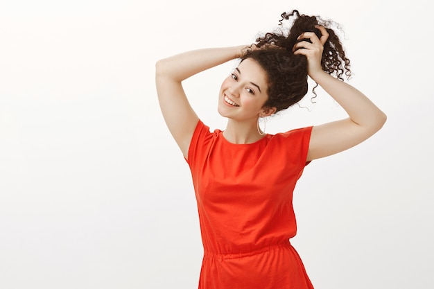 Retrato de uma mulher europeia alegre e bonita em um vestido vermelho casual da moda