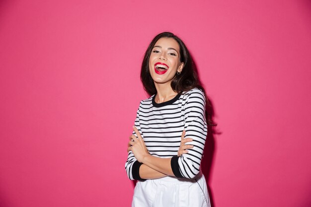 Retrato de uma mulher feliz, em pé com os braços cruzados