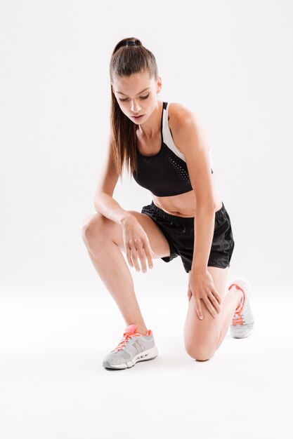 Retrato de uma mulher jovem cansado fitness descansando enquanto está sentado