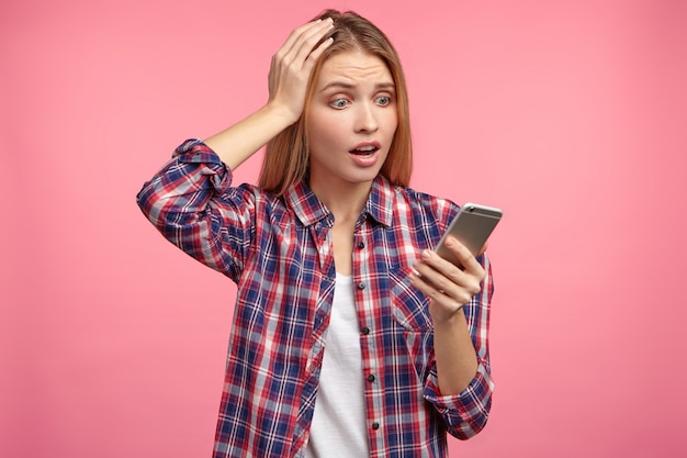 Retrato de uma mulher loira com camisa listrada e telefone