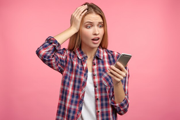 Retrato de uma mulher loira com camisa listrada e telefone