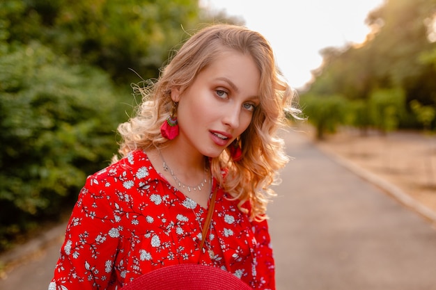 Retrato de uma mulher loira elegante e atraente sorridente, com blusa vermelha, roupa de verão e brincos sorrindo