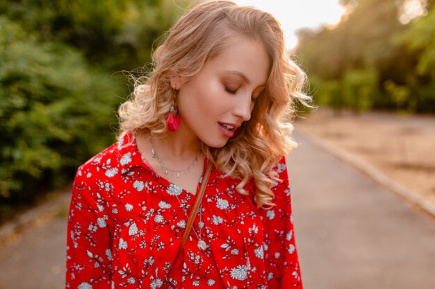 Retrato de uma mulher loira elegante e atraente sorridente, com blusa vermelha, roupa de verão e brincos sorrindo