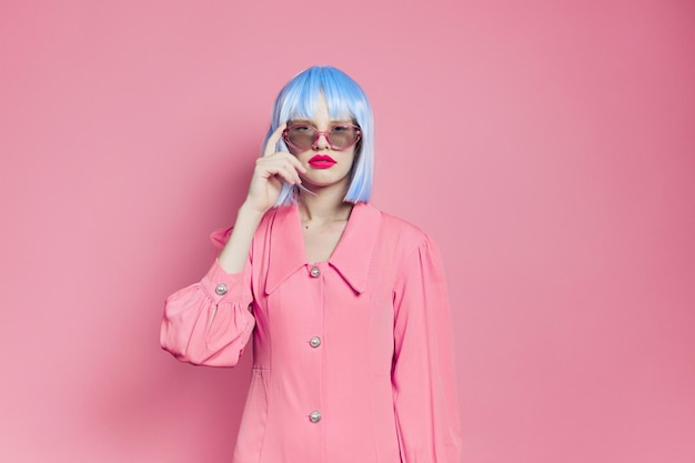 Retrato de uma mulher maquiagem brilhante moda óculos de sol fundo rosa