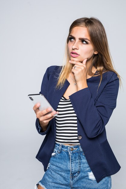 Retrato de uma mulher pensativa usando um celular isolado