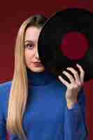 Foto grátis retrato de uma mulher segurando um disco de vinil