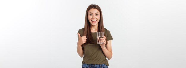 Retrato de uma mulher sorridente caucasiana atraente isolada em uma foto de estúdio branca bebendo água