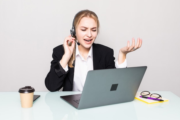 Retrato de uma mulher sorridente com o operador de linha de laptop portátil com fones de ouvido no escritório