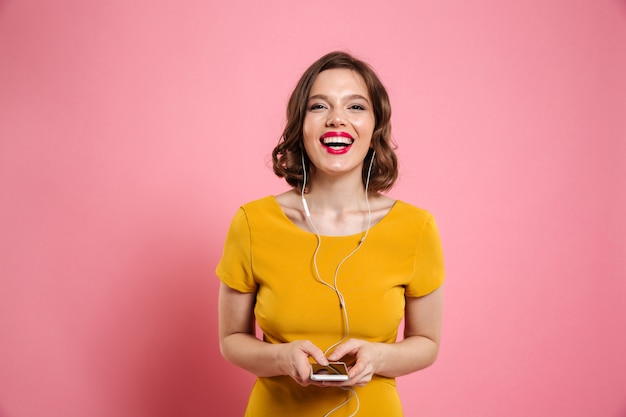 Retrato de uma mulher sorridente em fones de ouvido, ouvindo música