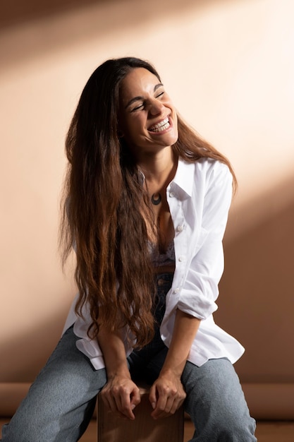 Retrato de uma mulher sorridente, posando com uma camisa branca