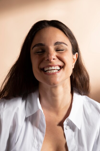 Retrato de uma mulher sorridente, posando com uma camisa branca