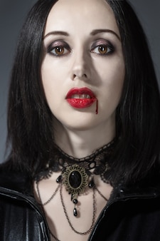 Retrato de uma mulher vampira com uma boca ensanguentada e presas de dentes celebrando um feriado diabólico feliz dia das bruxas