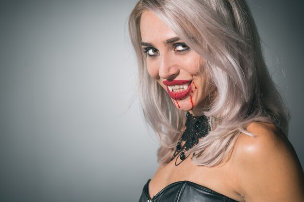 Retrato de uma mulher vampira com uma boca ensanguentada e presas de dentes celebrando um feriado diabólico feliz dia das bruxas
