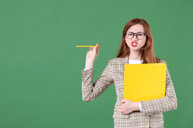 Retrato de uma professora posando com uma lima amarela em verde