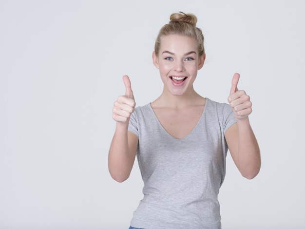 Retrato divertido de uma mulher fazendo sinal de positivo - isolado no fundo branco