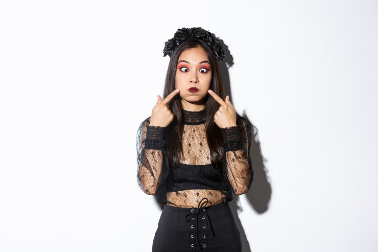 Foto grátis retrato do animador engraçado garota asiática no feriado de halloween, fazendo caretas, fazendo caretas e cutucando as bochechas, em pé sobre um fundo branco.