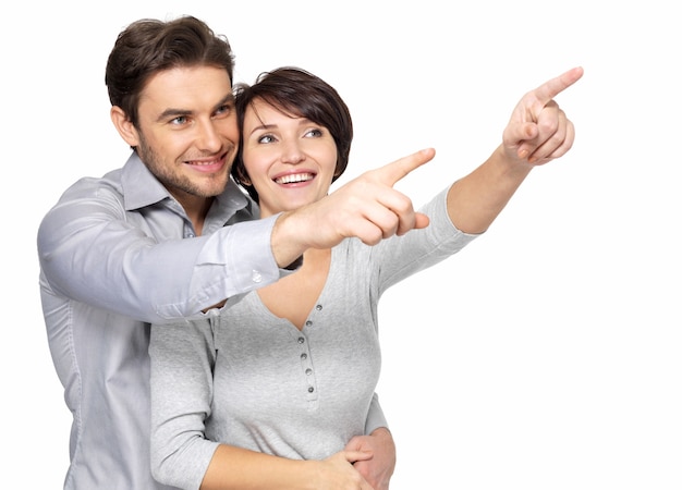 Foto grátis retrato do casal feliz olhando e apontando para a distância.