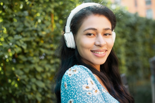 Retrato do close-up da mulher lateral com fones de ouvido