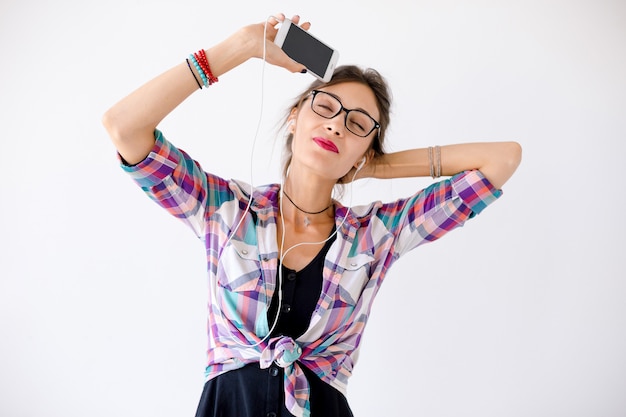 Retrato do close-up de jovem com fones de ouvido, ouvindo música