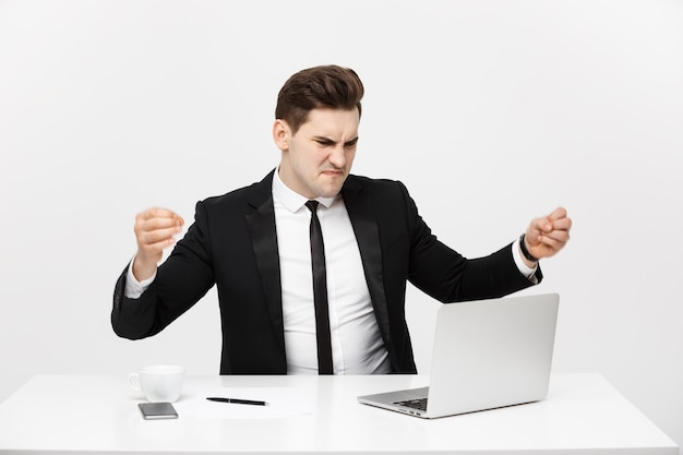 Retrato do conceito de negócio do empresário com raiva gritando, sentado no escritório, isolado sobre o fundo branco.