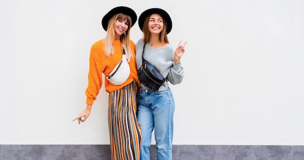 Foto grátis retrato do estilo de vida ao ar livre de duas mulheres jovens se divertindo juntos.