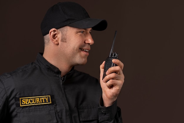 Retrato do guarda de segurança masculino com estação de rádio